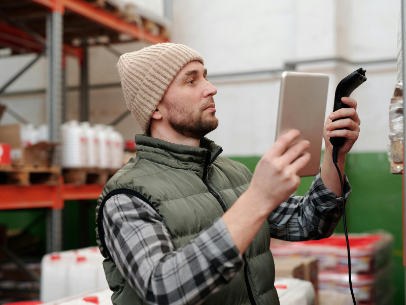 Warehouse worker using a barcode scanner and tablet for inventory