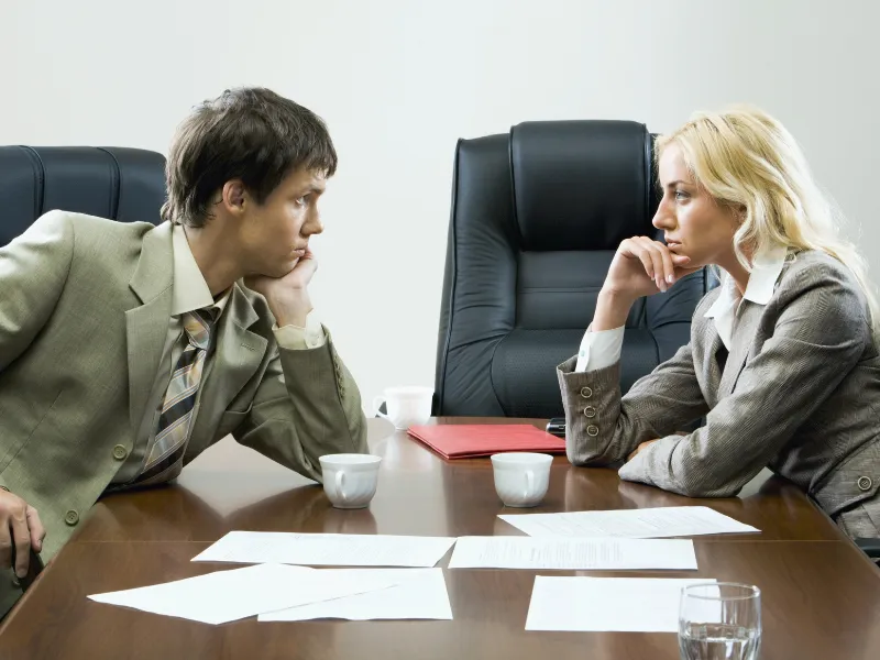 Two professionals negotiating vendor managed inventory terms in office setting