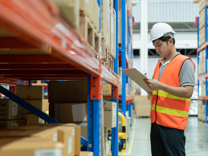 Employee checks inventory records in a fulfilment center storage area