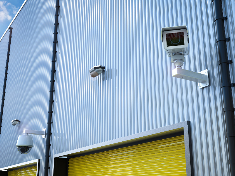 Multiple surveillance cameras monitoring the exterior of a warehouse facility