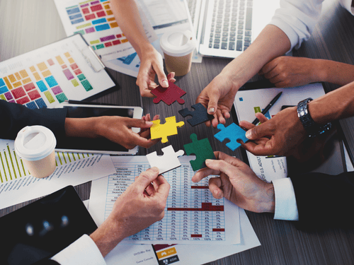 Team connecting puzzle pieces to represent collaborative planning for optimized API integration across platforms