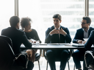 Team of business professionals discussing inventory management plans at a conference table