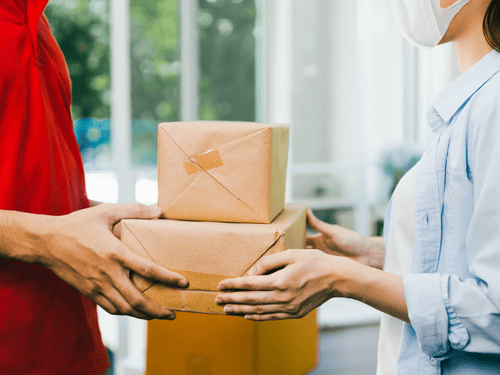 Courier delivers parcels to a customer, highlighting efficient delivery solutions for every SME