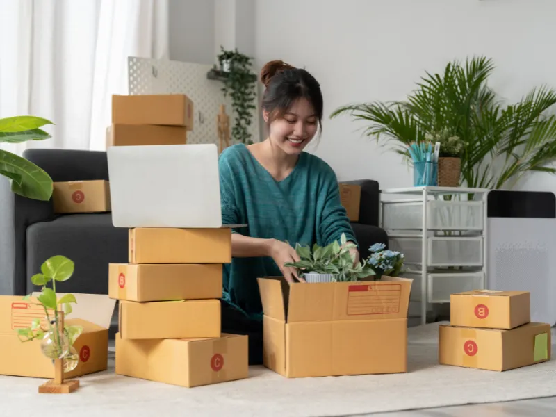 Entrepreneur prepares plants for shipment as part of her eco-friendly fulfillment business operations