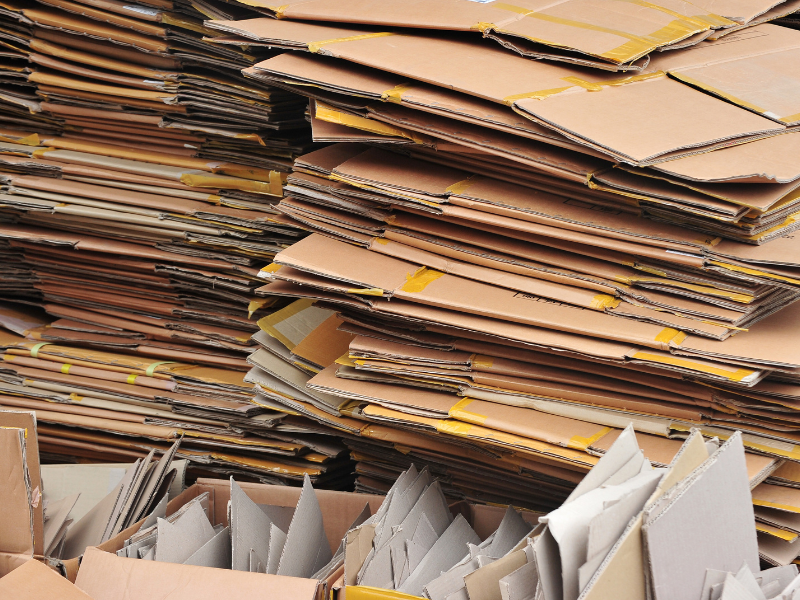A large pile of flattened cardboard boxes prepared for recycling or packaging reuse