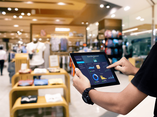 Store staff uses tech tools on a tablet to manage retail inventory and performance