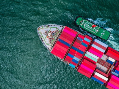 Large cargo ship transporting containers over ocean as part of global fulfillment logistics networks