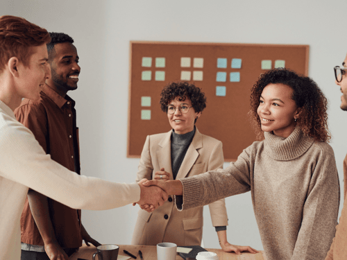 A diverse team discusses strategy at a table, coordinating effective fulfillment and distribution plans